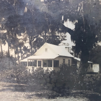 Captain Frank Forster's white, one-story Florida home surrounded by oaks.