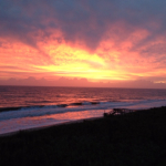 Early sunrise lights up the sky over the Atlantic Ocean coloring the waves with an amber glow