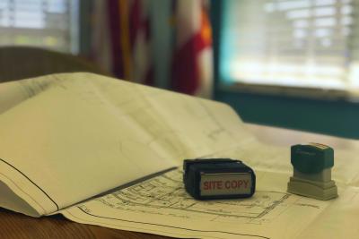 Drawings for construction project with a site plan stamp used by the Building Official in the permit review process