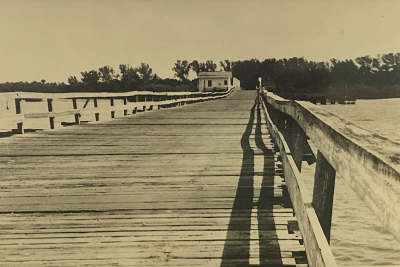Low and long wooden bridge stretches ahead across the Indian River at Wabasso.