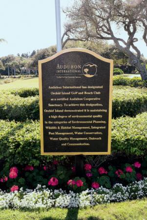 A decorative sign certifying the Orchid Island Golf and Beach Club as a certified Audubon Cooperative Sanctuary