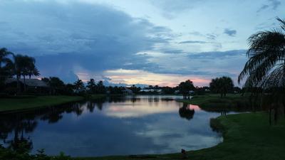 A lake of Orchid's golf course acts as a mirror on a cool, blue evening, as it reflects the homes and landscaping around it