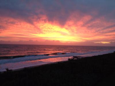 Early sunrise lights up the sky over the Atlantic Ocean coloring the waves with an amber glow