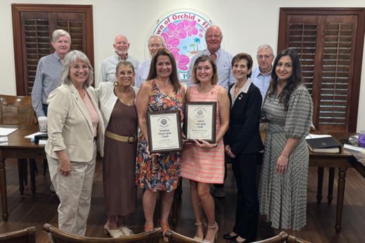 A group photo with the Town Council, Town Manager, Town Clerk, Florida Association of City Clerks President and local Clerks in front of the dais and Town seal. 